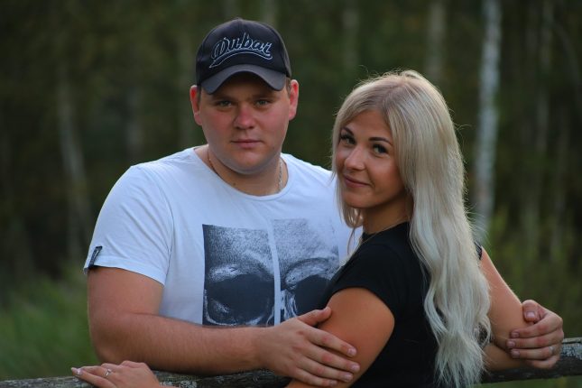 Mężczyzna i blondynka przytulają się na tle zieleni